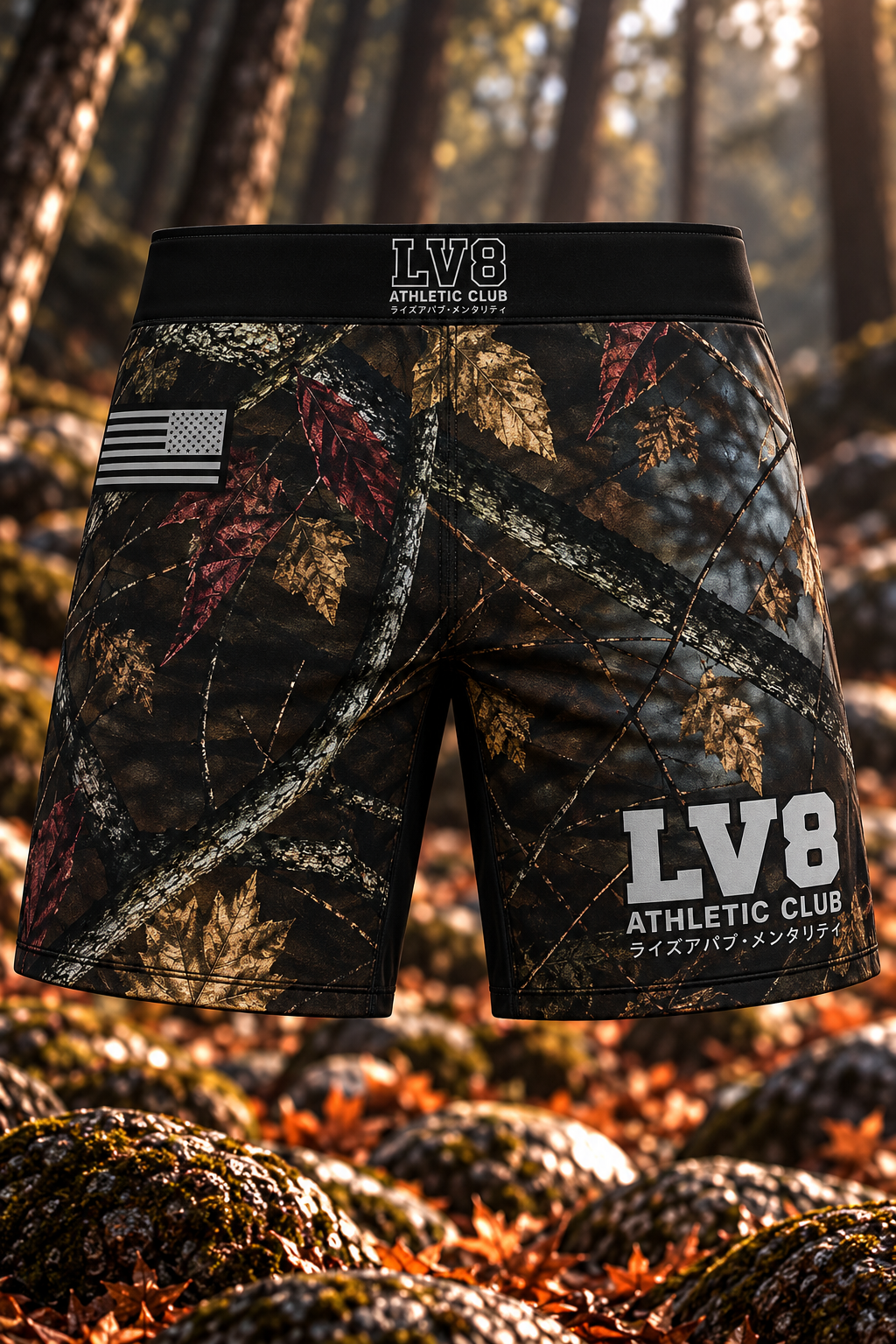Front view of men's LV8 Woods shorts in autumn woodland camouflage, with a black waistband, gray LV8 branding, and monochrome American flag.